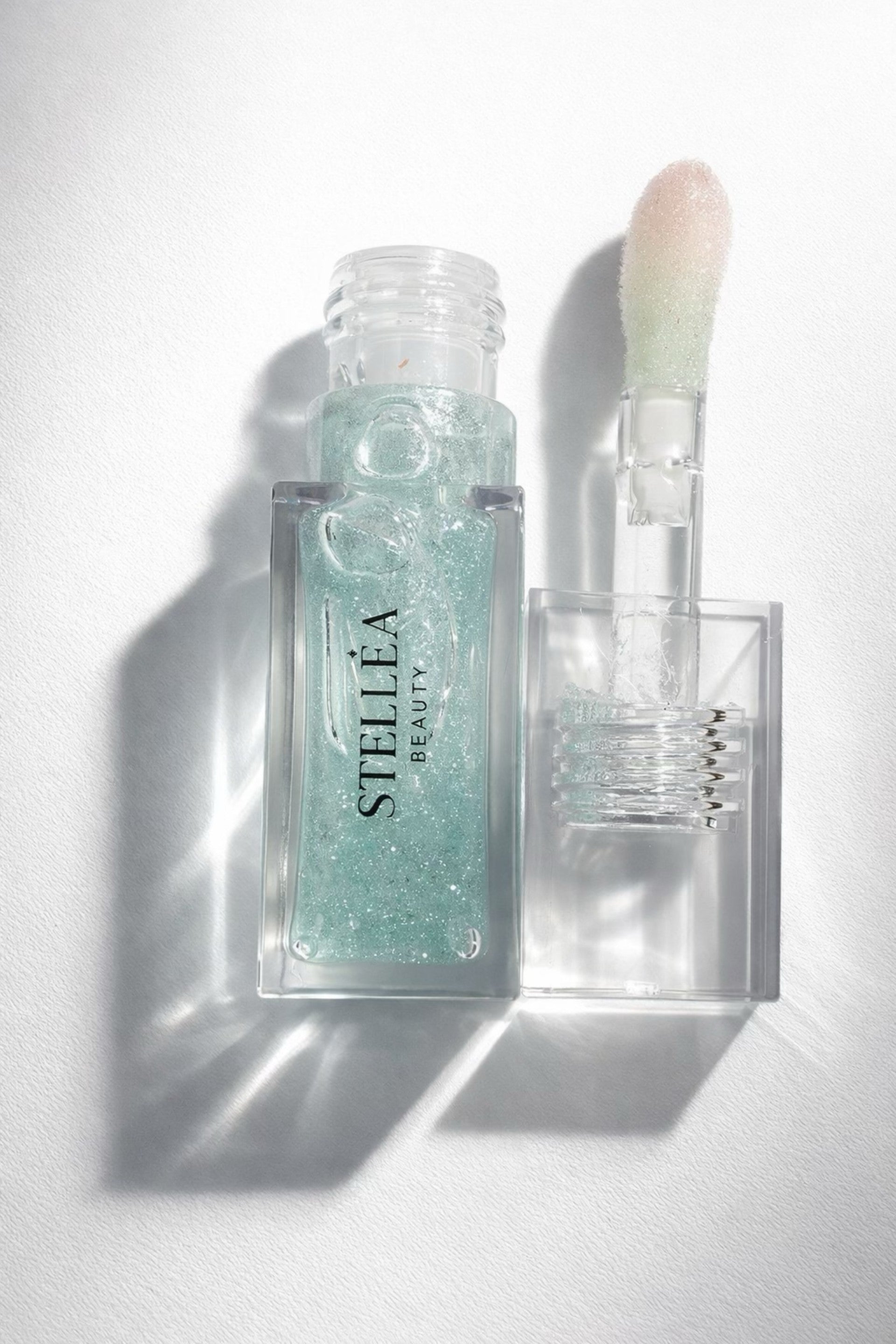 Huile à lèvres STELLEA Emerald Glow en flacon transparent, texture nourrissante, légère odeur de menthe.